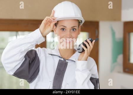 hispanic female construction worker using walkie-talkie Stock Photo