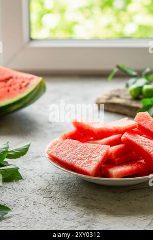 Slice of fresh watermelon in plate on white stone background Stock Photo
