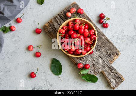 Fresh ripe red cherries in bowl on white stone background, heap of summer fruits concept Stock Photo