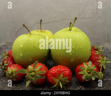 Four apples and eight strawberries fresh and ready to eat looking delicious Stock Photo
