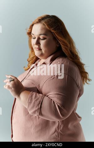 A woman in a pink shirt looks down thoughtfully. Stock Photo