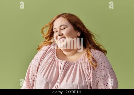 A woman with long red hair smiles brightly. Stock Photo