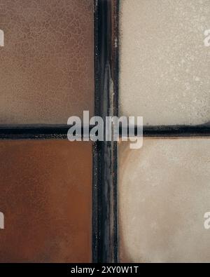 Close-up view of salt evaporation ponds showcasing the intriguing abstract patterns and textured surface, with varying shades of brown and off-white. Stock Photo