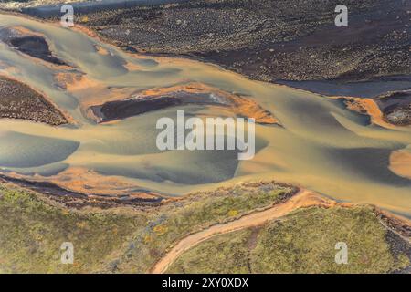 Top view of intricate curves and blend of colors in the riverside landscape of Holtsos, near the Holtsa River in Iceland, captured by drone. Stock Photo