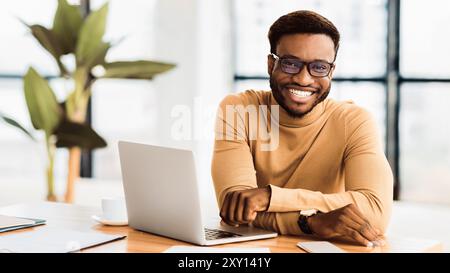 Portrait of handsome businessman looking at camera and smiling Stock Photo