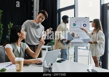 A diverse team works on a startup project, analyzing charts and discussing ideas. Stock Photo