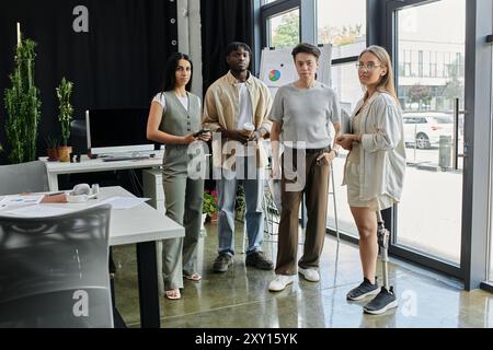 Team members, including woman with prosthetic leg, discuss project in modern office Stock Photo