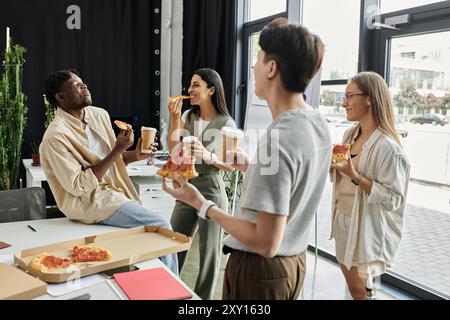 A group of four colleagues take a break from work, enjoying pizza and coffee together. Stock Photo