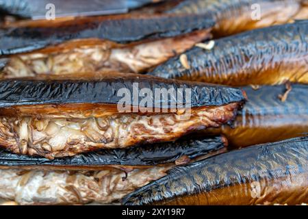 Freshly smoked fish is displayed at a vibrant market, enticing shoppers with rich aromas. Stock Photo