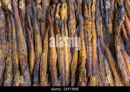 Dried fish laid out in intricate patterns at a local market during daylight hours Stock Photo