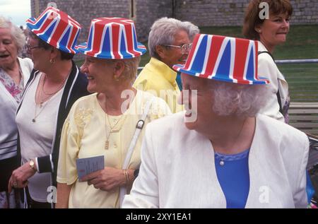 Royal wedding of Prince Edward and Sophie Rhys-Jones at Windsor Castle, Windsor, Berkshire, England  19th June 1999. Three middle aged women on a day out, all wearing souvenir hats decorated as Union Jacks. 1990s UK HOMER SYKES Stock Photo