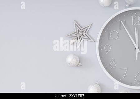 Creative Christmas layout made with silver Xmas baubles, star and gray and white wall clock on gray background. Minimal Christmas eve or New Year idea Stock Photo