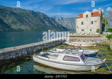 Stoliv village on Kotor Bay with fishing boats in the foreground, Kotor Bay, Montenegro Stock Photo