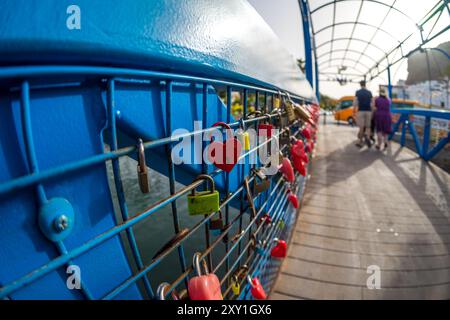 Heart-shaped padlocks as a symbol of love on the metal fence of the bridge. Stock Photo