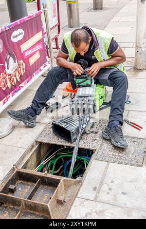 Cannes France,Center Centre Croisette,Rue Hoche,utility repairman technician,North African man worker,upgrading repairing Internet communications netw Stock Photo