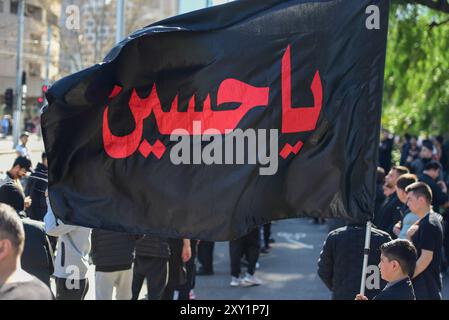 Melbourne, Victoria, Australia. 25th Aug, 2024. Islamic flag is seen during Arbaeen procession. The 16th annual Arbaeen processions is organised by Ashura. Melbourne Shia Muslim community commemorates Arbaeen - 40th day after Ashura, day of death of Imam Hussain, grandson of Prophet Mohammad. The procession marched from Queen Victoria Gardens to Birrarung Marr. (Credit Image: © Alexander Bogatyrev/SOPA Images via ZUMA Press Wire) EDITORIAL USAGE ONLY! Not for Commercial USAGE! Stock Photo