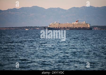 ZADAR, CROATIA - AUG 9, 2024: The Mein Schiff 6 (TUI Cruises) sailing away from Zadar at dusk, Croatia Stock Photo