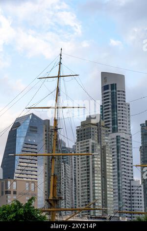 The skyline of Puerto Madero in Buenos Aires, Argentina, including the Alvear Tower, tallest building in Argentina.  In the foreground is the mast of Stock Photo