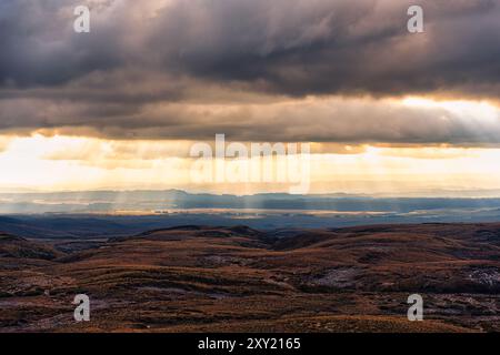 Golden sunbeam shining through cloudy over autumn wilderness in New Zealand Stock Photo