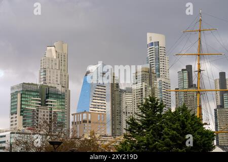 The skyline of Puerto Madero in Buenos Aires, Argentina, including the Alvear Tower, tallest building in Argentina.  In the foreground is the mast of Stock Photo