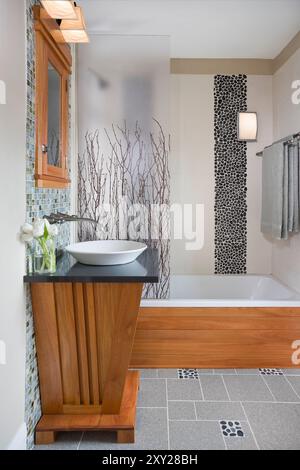 Side view of bathroom with custom vanity and blue glass tile behind sink Stock Photo