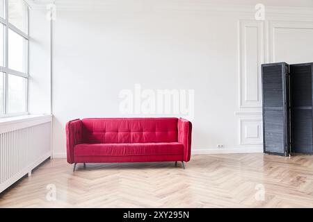 The modern living room has a red sofa, parquet floor with brown tones and a smooth polished surface. With space to copy. High quality photo Stock Photo