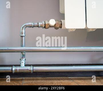 Connecting a radiator with stainless steel pipe fittings Stock Photo