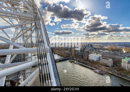 Aerial view of the River Thames, Buckingham Palace and Big Ben from The London Eye Ferris wheel, under a blue sky with backlit clouds. London, England Stock Photo