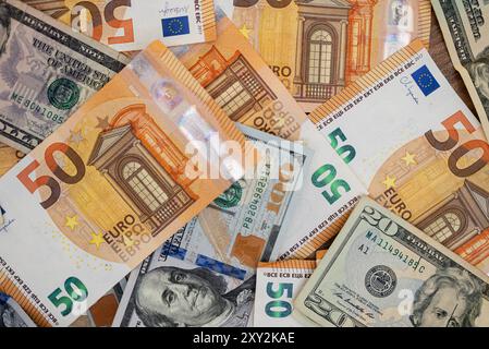 Close-up of various Euro and US dollar bills scattered on a surface. Represents currency exchange, financial transactions, and global economy concepts Stock Photo