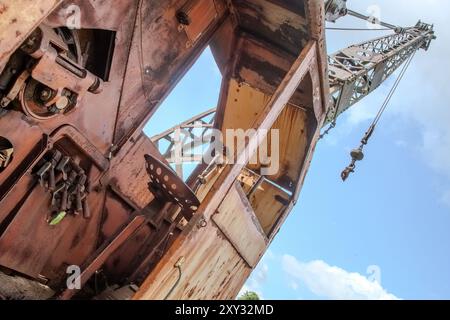 A vintage crane sits decommissioned in Cooperstown Junction, New York, resting in a field, showing its rustic charm. Stock Photo