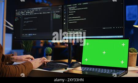 Green screen laptop in home office used by programmer for developing software applications. Mockup notebook used by teleworking IT specialist for programming, camera B close up Stock Photo