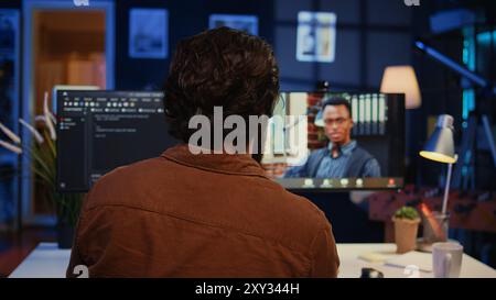 Remotely working software developer talking with manager during online videocall, updating him on programming task progress. IT specialist in teleconference meeting with team leader, camera B Stock Photo