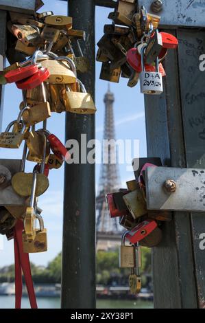 The Eiffel Tower glimpsed through the balustrade of Pont de Bir-Hakeim, a bridge near to the iconic monument in Paris, France.  Attaching locks to bridges in Paris is officially not allowed, since the partial collapse of Pont des Arts in 2014, however travellers still do this with locks appearing at the balustrades in front of the Roman Catholic Church, Basilique du Sacré-Coeur de Montmartre, in addition to Pont de Bir-Hakeim. Stock Photo