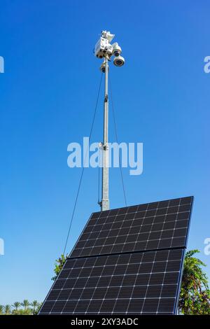 Mobile CCTV surveillance camera unit with solar panel and blue sky Stock Photo