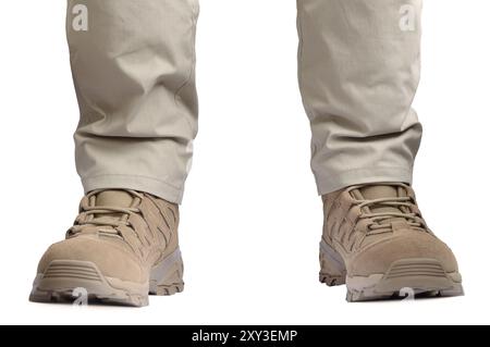 Beige tactical desert boots and durable ripstop pants, khaki tan suede leather army combat footwear and casual men's trousers brand new apparel detail Stock Photo