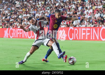 Madrid, Spain. 27th Aug, 2024. Raphinha (R) of Barcelona vies with Alvaro Garcia of Rayo Vallecano during the Spanish league (La Liga) football match in Madrid, Spain, Aug. 27, 2024. Credit: Gustavo Valiente/Xinhua/Alamy Live News Stock Photo