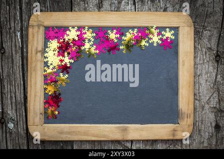 Christmas frame of confetti on vintage blackboard blank. Winter holidays concept Stock Photo