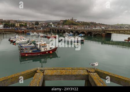 Folkestone, Kent, England, UK, October 29, 2016: Boats in Folkestone Harbour with the old Railway Bridge in the background Stock Photo