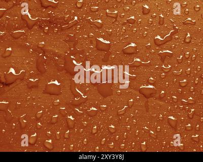 Water drops on russet orange colored metallic surface Stock Photo