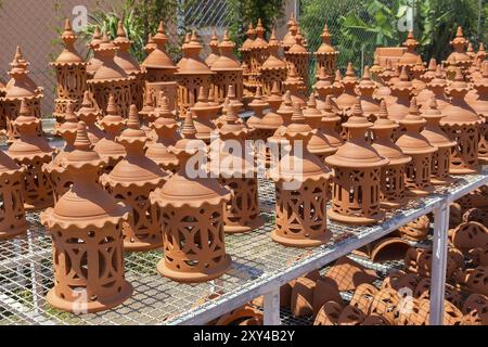 Many orange clay pots on rack outdoors at pottery shop Stock Photo