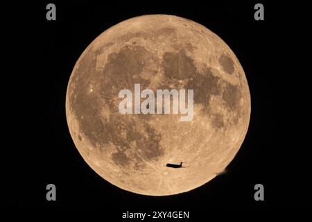 An aeroplane flies past in front of the so-called super full moon in August, Frankfurt, Hesse, Germany, Europe Stock Photo