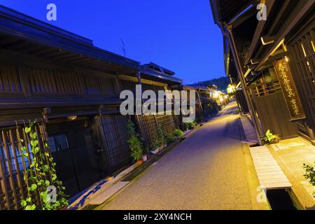 Takayama, Japan, July 10, 2015: A line of connected traditional wooden buildings in old town district of Hida-Takayama, Gifu, Japan. Tilted wide angle Stock Photo