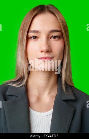 Young Woman in Black Blazer Against Green Screen Stock Photo