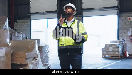 Black man, online or tablet in warehouse for inspection, inventory check or stock management for website. Logistic, employee or supervisor with Stock Photo