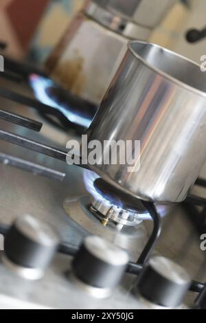 Close up of a blue gas flame, cooking a water pot in kitchen Stock Photo