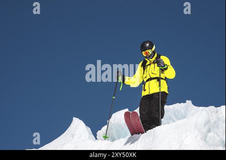 A freerider skier in complete outfit stands on a glacier in the North Caucasus. Skier preparing before jumping from the glacier Stock Photo