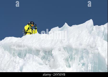 A freerider skier in complete outfit stands on a glacier in the North Caucasus. Skier preparing before jumping from the glacier Stock Photo