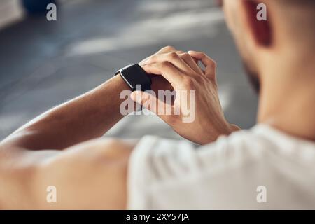 Man, fitness and checking with smart watch for tracking, performance or progress on workout at gym. Closeup of male person or athlete with wristwatch Stock Photo