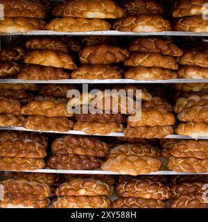 Loaves of freshly braided and baked challah egg bread rest on display racks outside a bakery on a Jerusalem street on the eve of the Jewish sabbath. Stock Photo