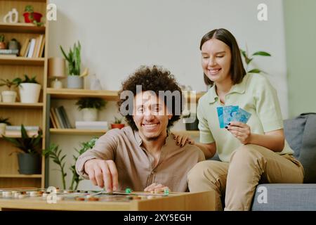 Cheerful Man And Woman Playing Tabletop Game At Home Stock Photo